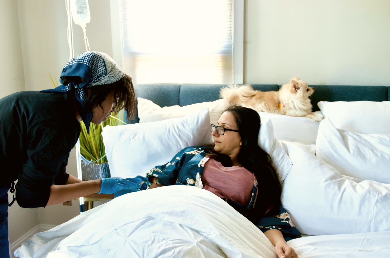 A client resting with her dog while an infusion runs